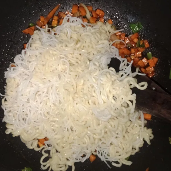 Masukkan mie. Aduk-aduk hingga bumbu tercampur rata dan wortel tarcampur rata. Matikan kompor.