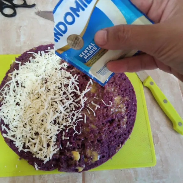 Setelah matang, bagi kue menjadi 2 bagian oles dengan blueband dan taburi keju parut, tambah skm. tutupkan dengan kue satunya