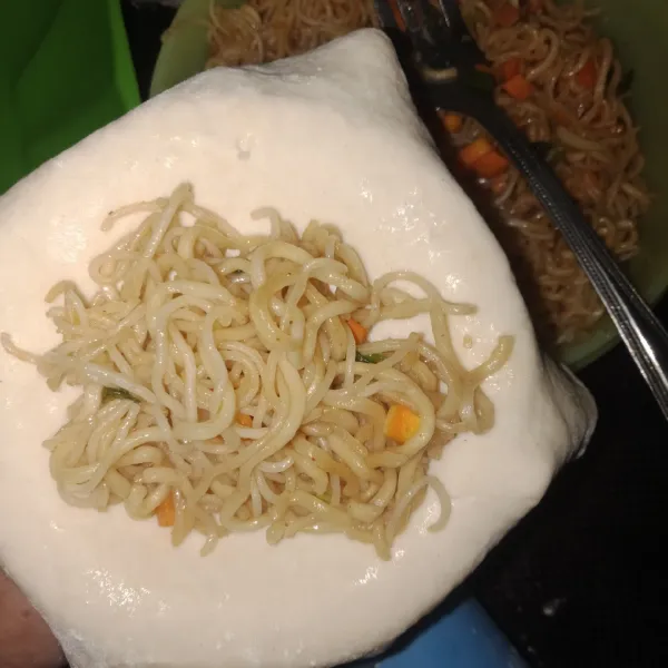 Saat adonan sudah kalis, cetak adonan dengan cara pipihkan dengan rolling pin. Potong lalu masukkan mie. Bentuk hingga seperti pastel.