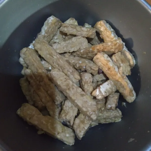 Campur rata bumbu halus yg telah ditambah air,lalu siramkan ke potongan tempe,aduk rata,diamkan 30 menit agar bumbu menyerap.