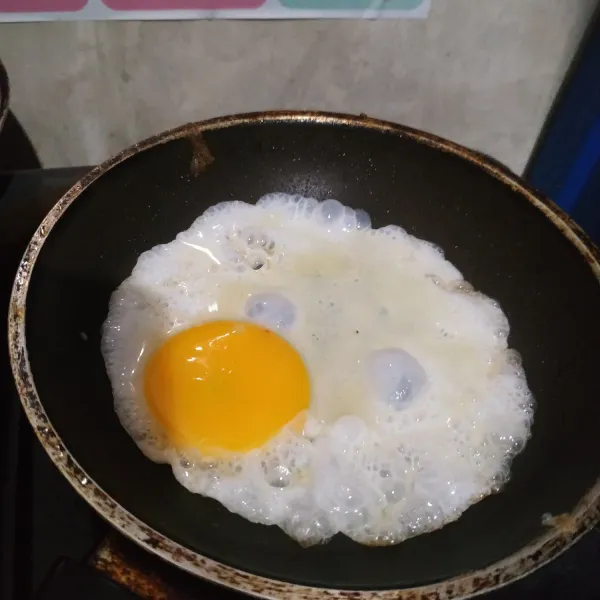 Panaskan minyak goreng di teflon. Ceplok telur lalu tabur sedikit garam. Masak sampai telur sampai matang. Angkat, sisihkan.