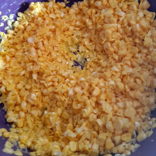 Kupas jagung. Lalu pipil dan hancurkan dengan ulekan.