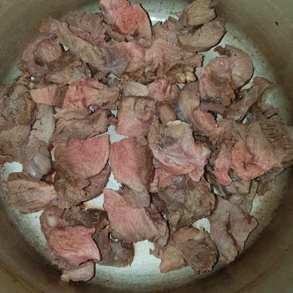 Rebus daging dalam air mendidih. Buang busa keruh dalam air rebusan. Matikan api,buang air rebusan dan potong daging sesuai selera.