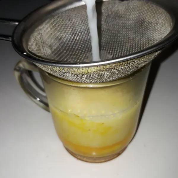 Selagi panas, saring susu cair ke dalam gelas yang berisi madu dan kuning telur. Aduk cepat sampai telur dan madu larut. Sajikan.