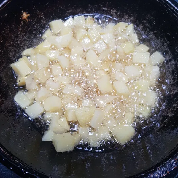 Kupas kentang dan potong dadu, lalu goreng hingga matang