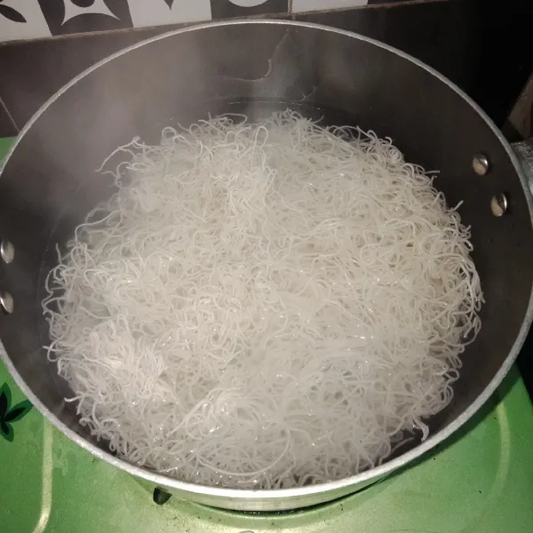 Pertama rebus air hingga mendidih. Lalu matikan kompor dan masukkan bihun beras. Rendam selama 10 menit tutup panci.