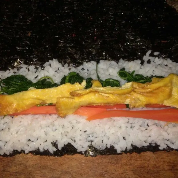 Tambahkan isian wortel, bayam dan telur lalu gulung.