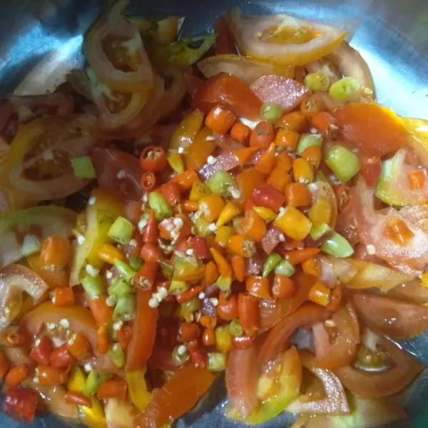 Potong-potong tomat dan cabe rawit.