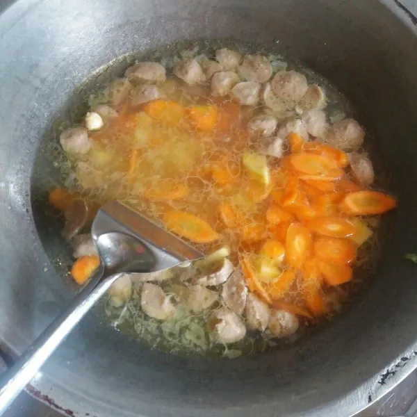 Kemudian rebus kentang dan wortel yang sudah dipotong-potong tadi ke dalam kuah baso.