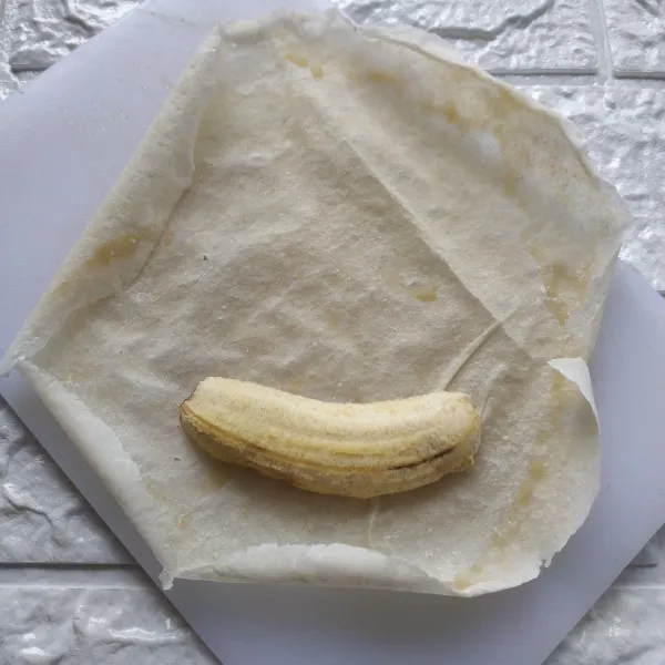 Ambil 1 lembar kulit lumpia, letakkan 1/2 buah pisang