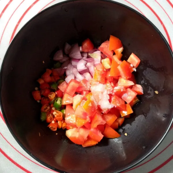 Buat sambal dabu-dabu, campur potongan tomat, bawang merah, cabe rawit, garam dan gula.