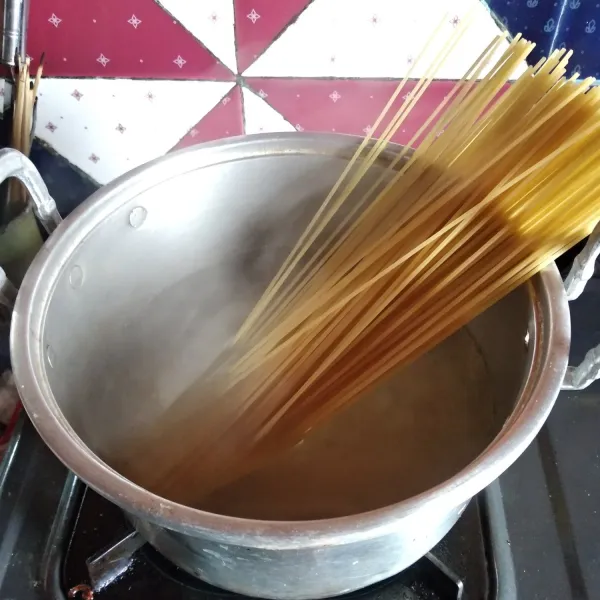 Didihkan air. Rebus spaghetti dengan minyak goreng dan garam selama 10 menit.