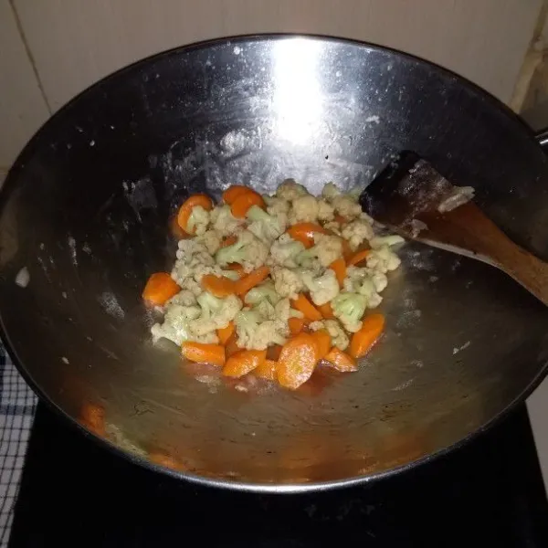 Masukkan kembang kol. Tambahkan saus tiram dan saus sambal. Masak hingga sayuran layu. Setelah air menyusut. Matikan api.