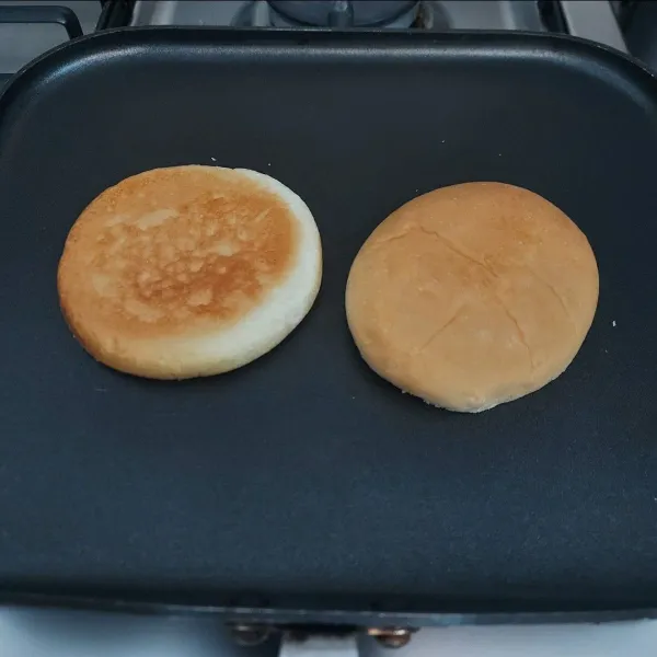 Panggang roti burger dengan 1 sdm margarin. Masak sampai kedua sisi roti kecoklatan. Angkat.
