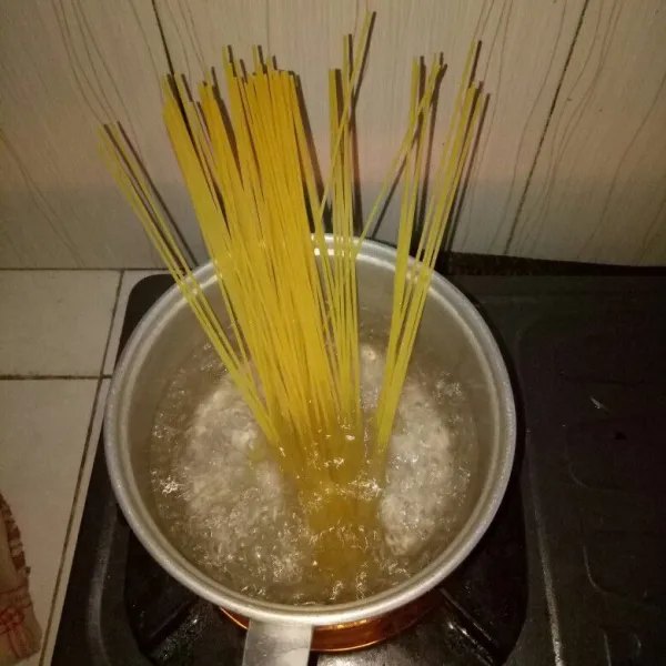 Siapkan panci dan didihkan air, beri 1 sdt minyak sayur. Rebus spaghetti selama 8 menit, tiriskan