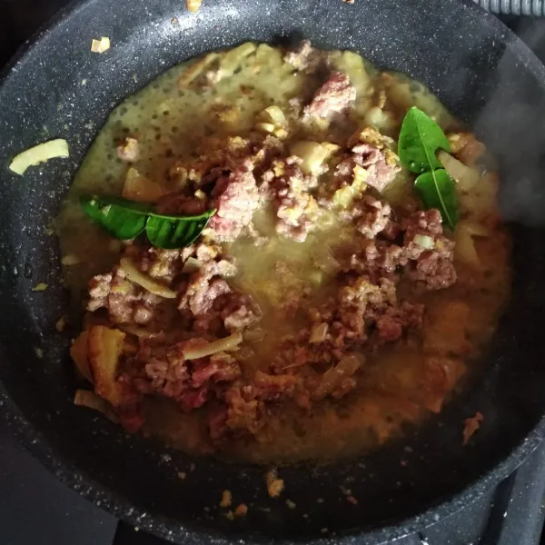 Masukkan daging giling dan daun jeruk. Masak sebentar tambahkan air. Masak hingga daging matang.