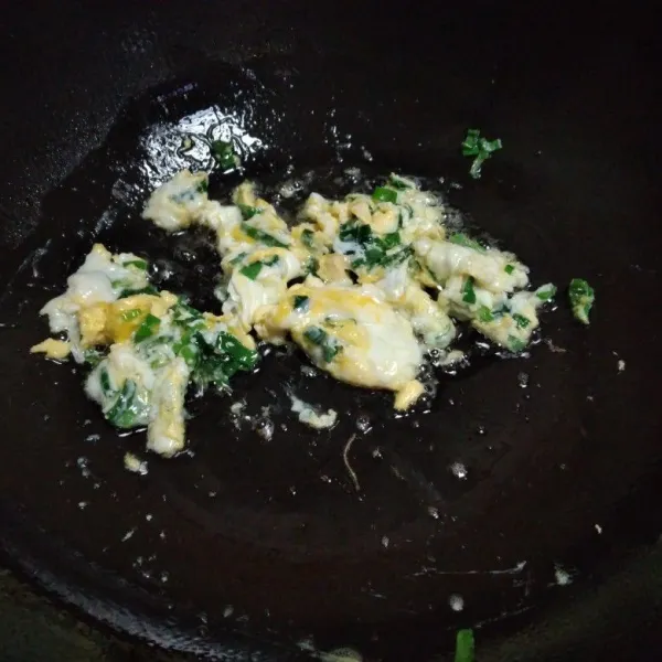 Panaskan minyak tumis daun bawang bagian hijau sebentar kemudian masukkan telur, orak arik telurnya, sisihkan kepinggir wajan.