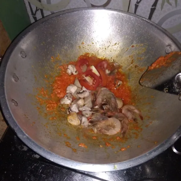 Masukkan udang, jamur, bakso, tomat diaduk sampai bumbu tercampur rata