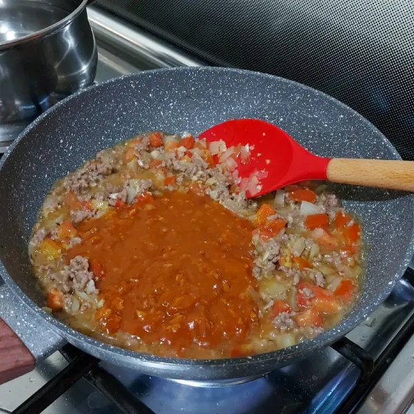 Masukan tomat dan italian seasoning, aduk rata. Masukan saus bolognese botol (Prego), aduk rata lagi.