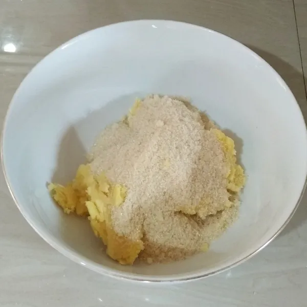 Siapkan wadah. Masukan tape yang sudah dihaluskan dan gula pasir. Remas -remas dengan tangan agar tercampur rata.