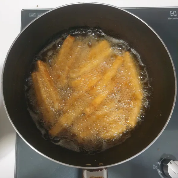 panaskan minyak goreng secukupnya, goreng tempe sampai berwarna kuning kecoklatan, angkat dan tiriskan.