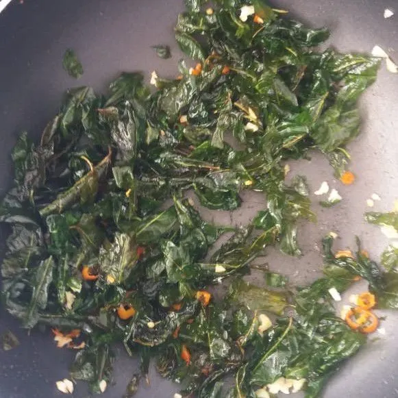 Tumis bawang putih dan cabai. Masukkan daun kangkung yang sudah digoreng. Tambahkan garam dan penyedap. Angkat