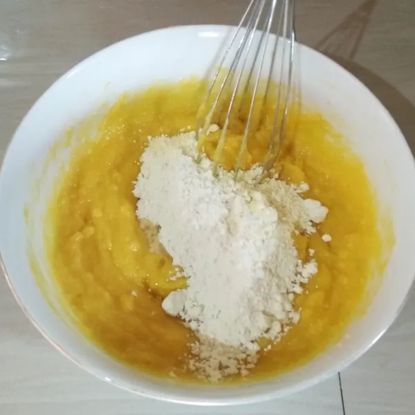 Masukkan terigu sedikit demi sedikit, sambil diaduk hingga tercampur rata.