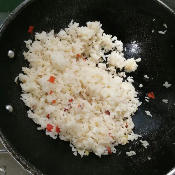 Masukkan nasi tambahkan garam, lada aduk hingga merata