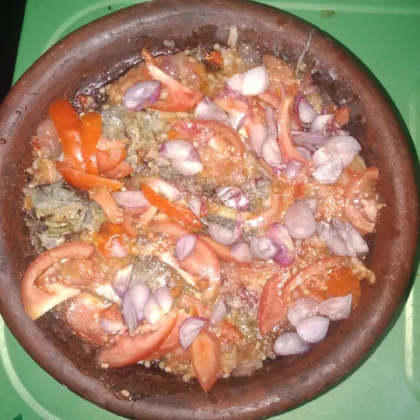 Letakkan ikan diatas sambal yang sudah di ulek lalu taburkan tomat dan bawang diatasnya lalu beri 2 sdm minyak goreng dan 3 sdm air.