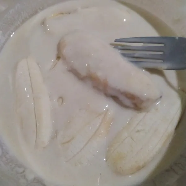 Masukkan pisang ke dalam adonan basah hingga seluruh bagian terlumuri.