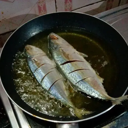 Goreng ikan dengan minyak panas. Bila sudah kecoklatan, angkat lalu sisihkan.