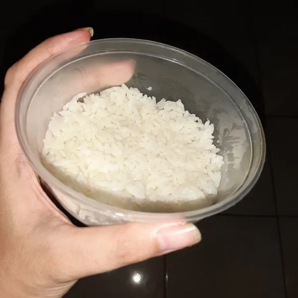 Cetak nasi di mangkuk bulat. Tekan-tekan agar padat dan tidak ambyar saat dikeluarkan dari cetakan. uUtuk satu porsi burger lakukan dua kali, satu untuk roti atas dan satu untuk roti bawah.