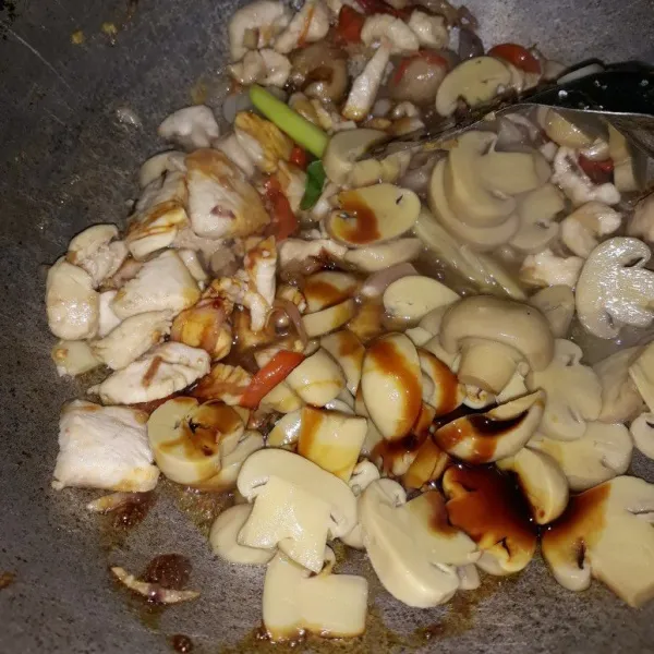 Selanjutnya masukkan jamur kancing, tambahkan kaldu bubuk dan kecap, masak sampai matang, sisihkan
