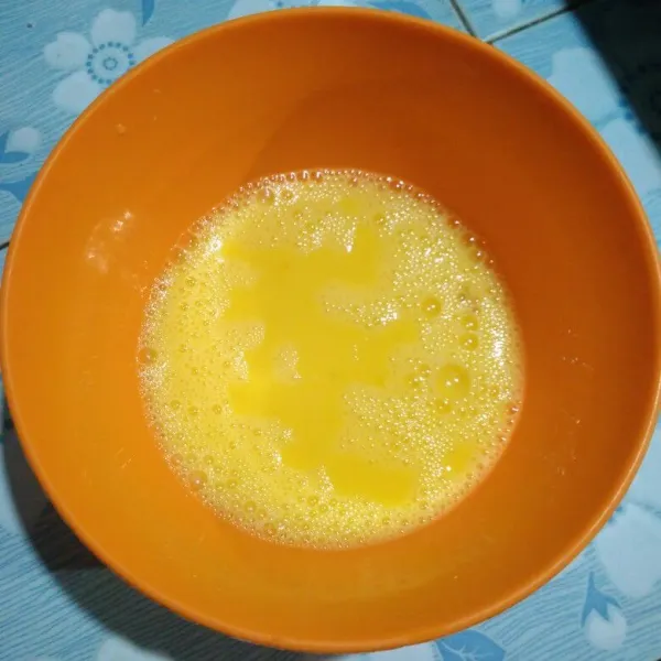 Kocok lepas telur dalam mangkuk.