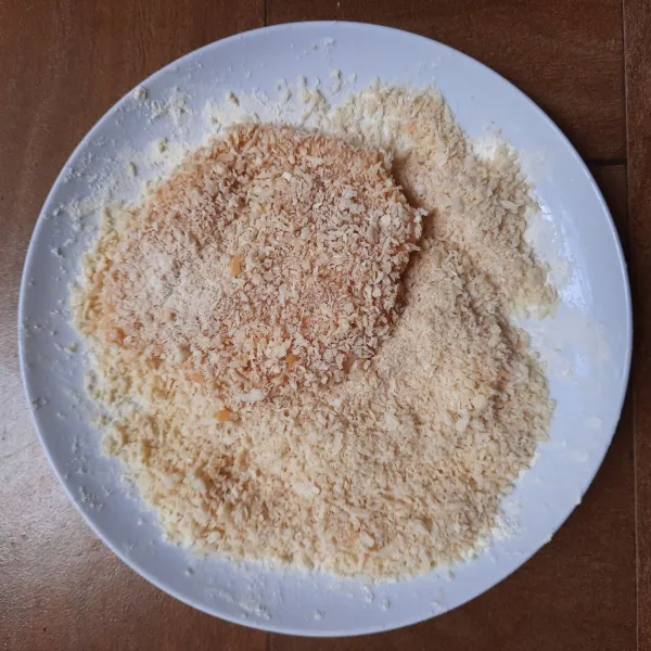 Gulingkan dada ayam ke tepung roti hingga seluruh permukaannya terbalut tepung roti.
