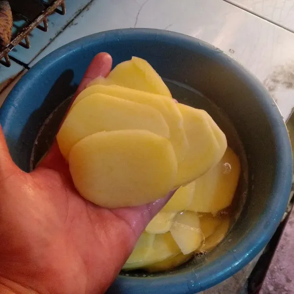 Potong tipis kentang dan bombay sisihkan