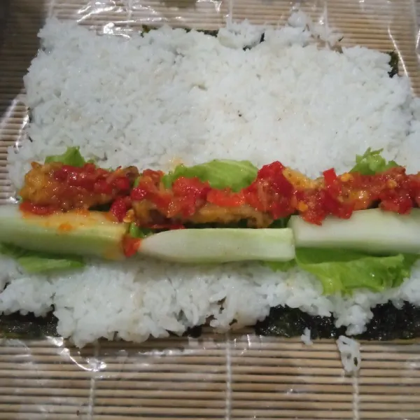 Timpa nori dengan nasi, rayakan. lalu tata tldaun selada, timun, ayam goreng dan sambal geprek.
