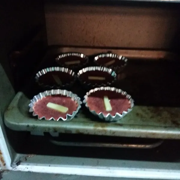 Lalu masukan ke cetakan yang sudah dioles margarin tipis, beri topping. Panggang di oven suhu 150 °C selama 25 menit. Sesuaikan oven masing- masing.