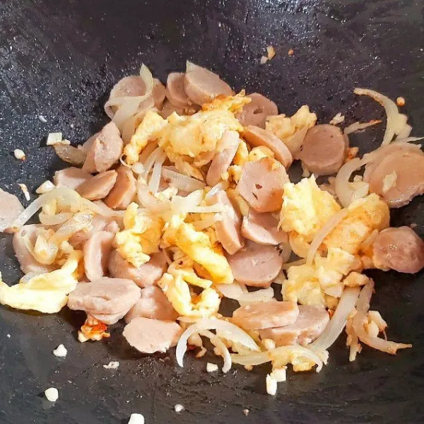 Panaskan minyak kemudian tumis bawang bombay lalu bawang putih, tumis sampai harum. Masukkan bakso dan telur kocok. Tambahkan kecap ikan.