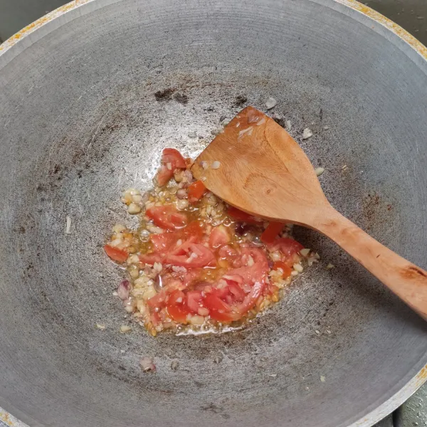 Tumis bawang merah dan bawang putih sampai harum. Masukkan tomat, aduk-aduk.