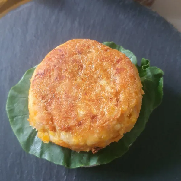 Oles dengan sambal, susun sayur, patty lalu tomat dan tutup lagi dengan nasi. taburi dengan wijen. Siap dihidangkan.