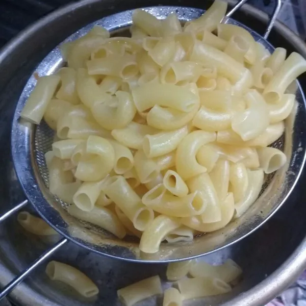 Rebus macaroni dan beri sedikit minyak agar tidak menempel. Masak sebentar saja. Lalu angkat dan siram dengan air dingin. Tiriskan.