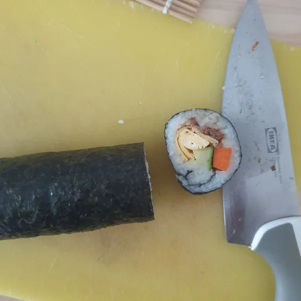 buka Sushi mat kemudian potong dengan menggunakan pisau yang tajam.