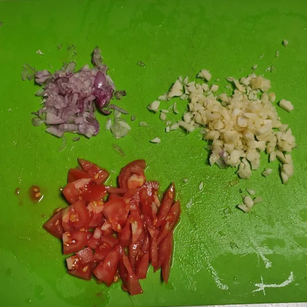 Cincang bawang merah dan bawang putih. Potong tomat kecil-kecil.