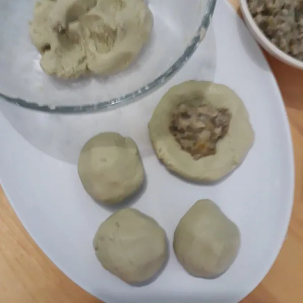Bentuk adonan bulat kecil beri isian kacang hijau.