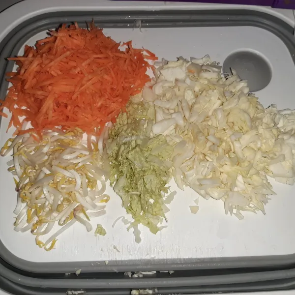Siapkan sayuran. Untuk wortel diparut. kol dan sawi diiris tipis.