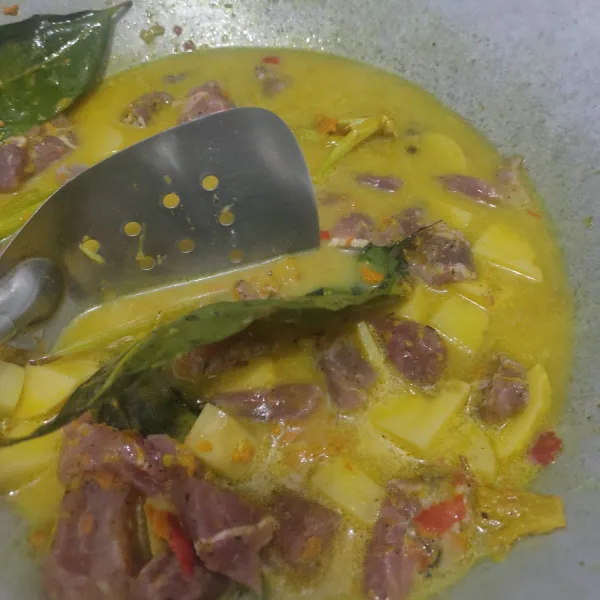 Masukkan santan, daging dan air sambil terus diaduk sampai mendidih. Di sini saya masak pakai metode 5.30.7 menit.