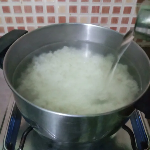 Masukkan nasi dan air dalam panci. Masak sampai airnya kental.
