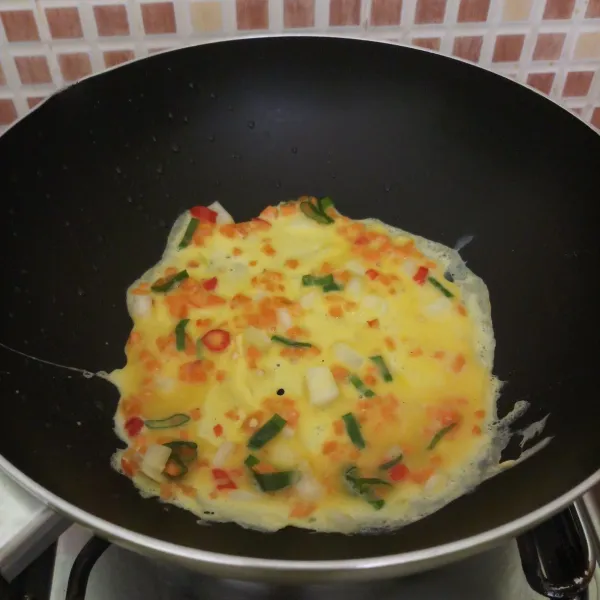 Panaskan teflon, oles dengan minyak. Tuang 2 sendok sayur kocokan telur, ratakan tipis bentuk persegi panjang. Masak sampai bawahnya agak coklat.