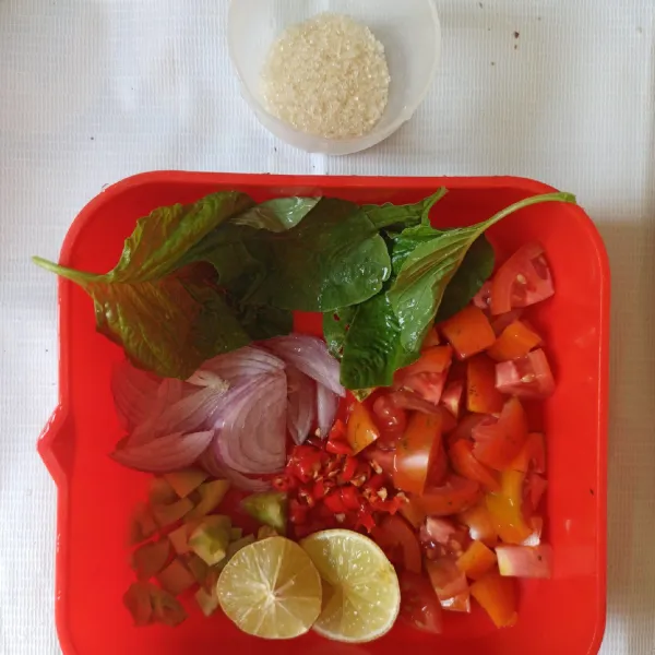Untuk membuat sambal dabu-dabu : Iris tomat dadu, iris tipis bawang merah. Peras jeruk nipis, ambil airnya.